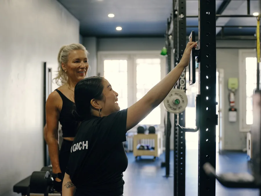 A Thrive Fit coach setting up a rack for a member in the Beaches studio