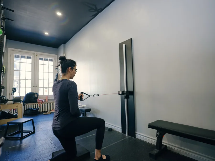 A member doing a kneeling cable row in a quiet corner of the Thrive Fit studio