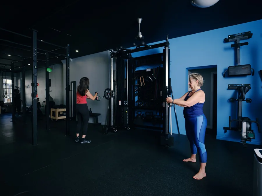 Thrive Fit: two members training side by side on the cable machines