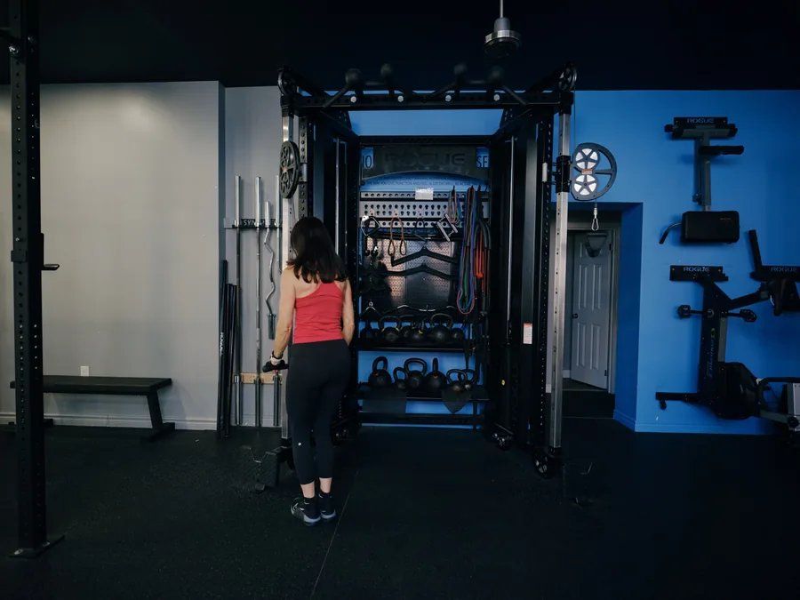 A member training in front of the equipment wall at Thrive Fit