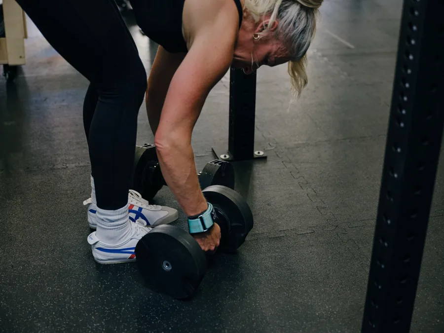 Close up of a member gripping a pair of dumbbells at Thrive Fit