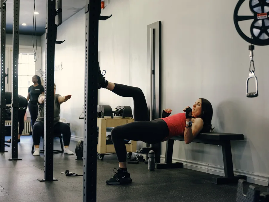 Thrive Fit: a member doing single-leg hip thrusts on a bench