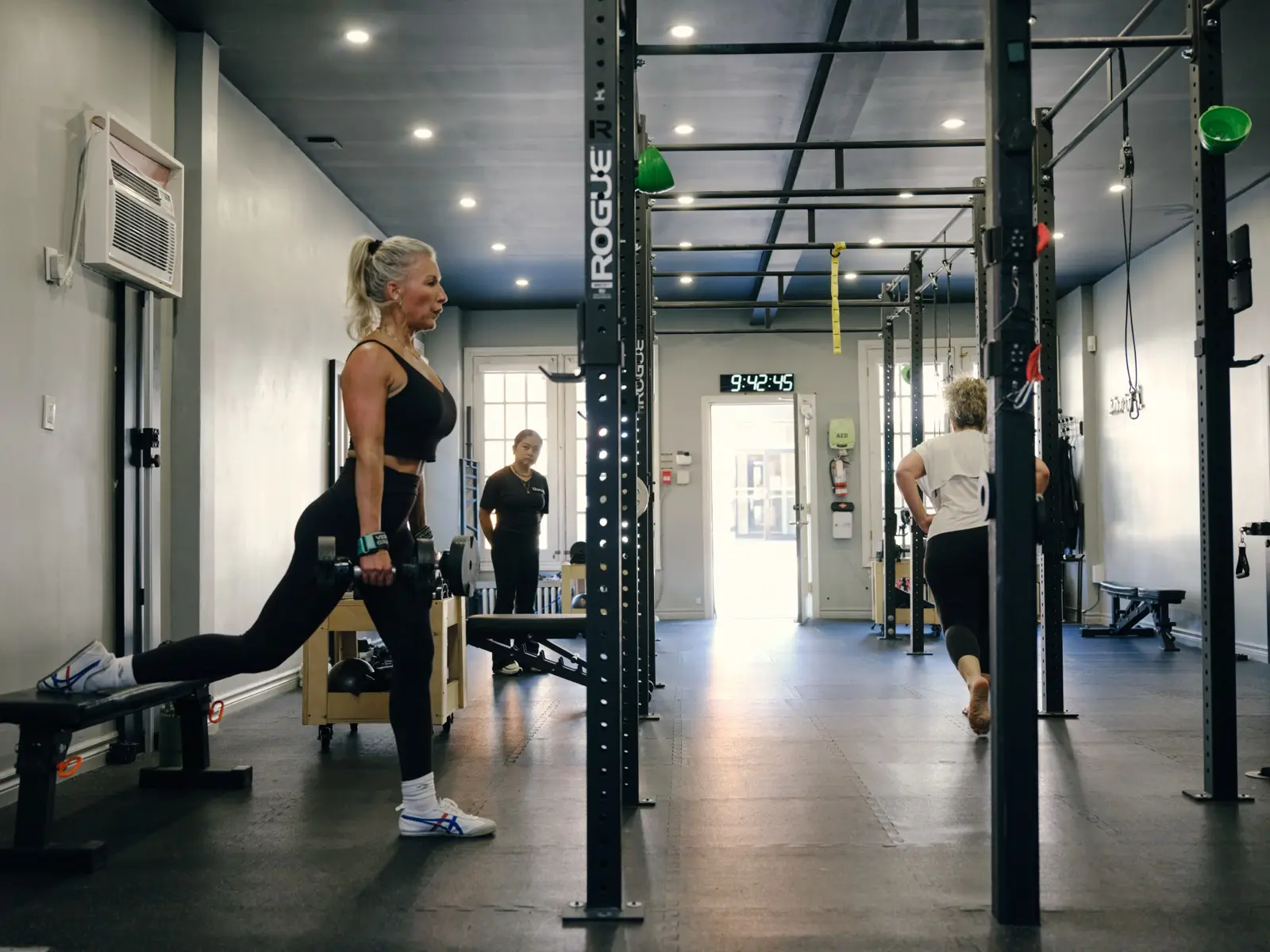Thrive Fit: a coach watching a member through a split squat